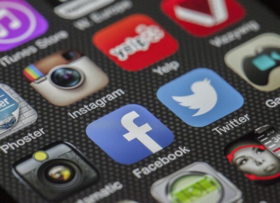 Close-up image of various social media app icons on a smartphone screen.